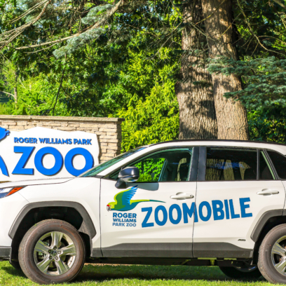 Zoomobile car in front of Zoo's entrance sign