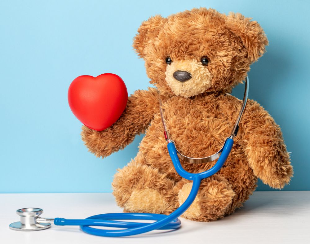 stuffed teddy bear holding a heart and a stethoscope